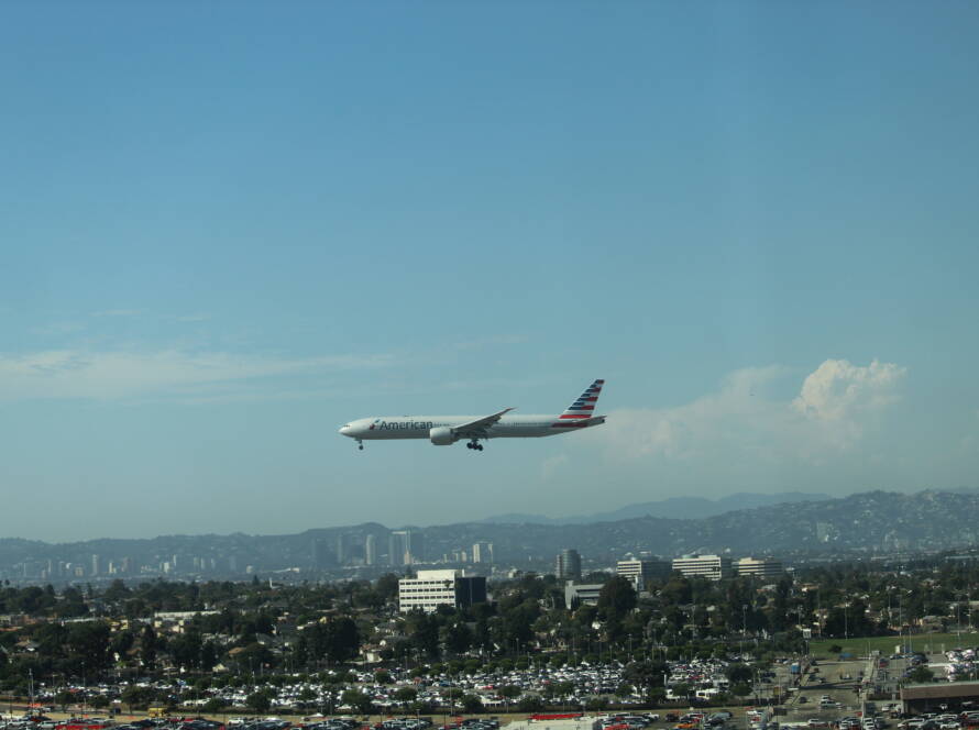 Aircraft descending toward Los Angeles airport with cityscape below, symbolizing strategic momentum and precision landing.